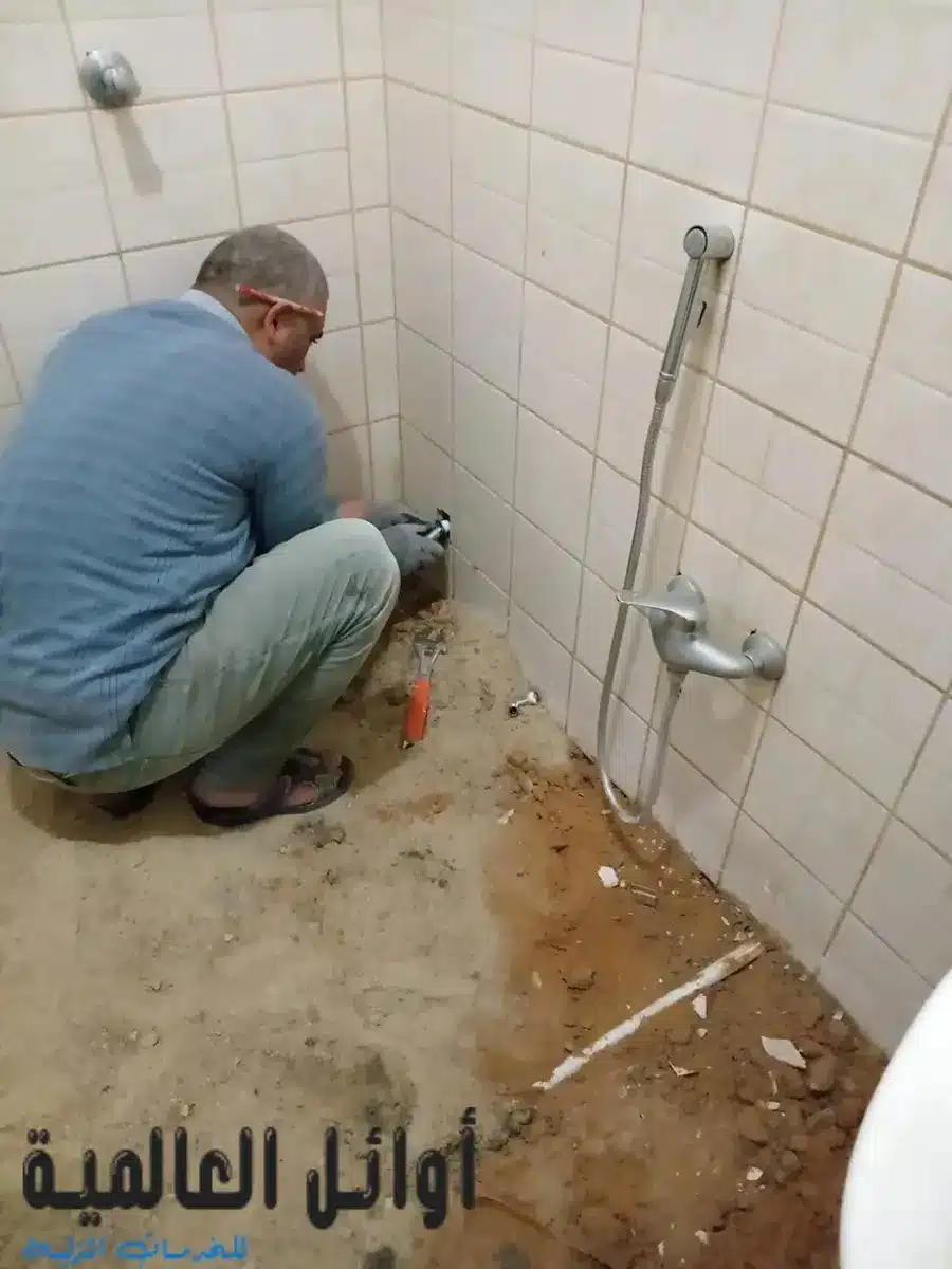 فني متخصص من شركة اوائل العالمية يستخدم جهاز كشف تسربات المياه الإلكتروني على جدار حمام في القصيم لتحديد مكان التسرب بدقة.